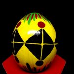 gelb grundiertes Ei mit schwarzen Dreiecken zum Quadrat mit roten Punkten und gelben Strichen